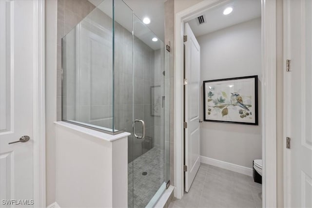 full bath with a stall shower, baseboards, visible vents, toilet, and tile patterned floors