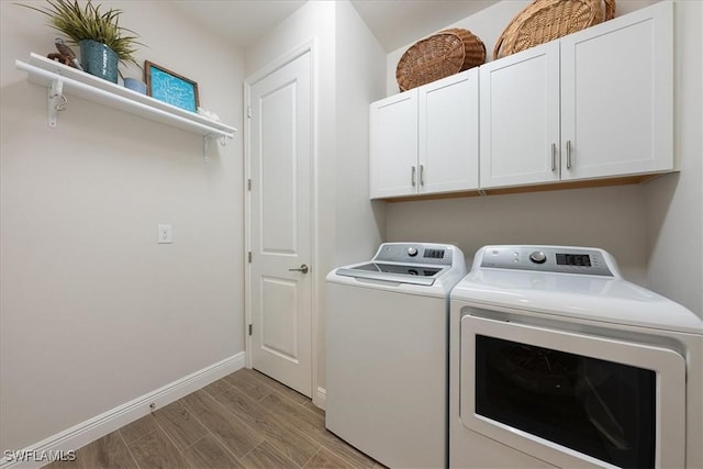 clothes washing area featuring light wood finished floors, washing machine and dryer, cabinet space, and baseboards