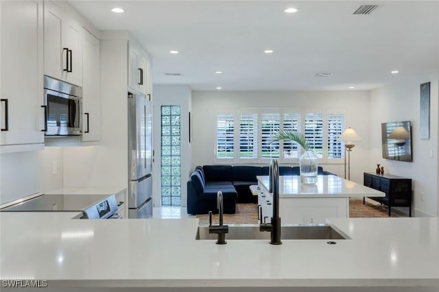 kitchen featuring recessed lighting, visible vents, white cabinets, and stainless steel appliances