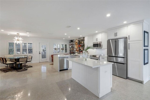 kitchen featuring a peninsula, a center island, recessed lighting, and appliances with stainless steel finishes