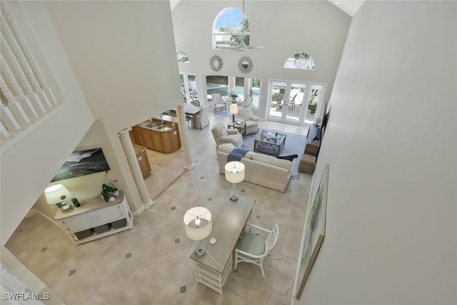 tiled living area with high vaulted ceiling and french doors