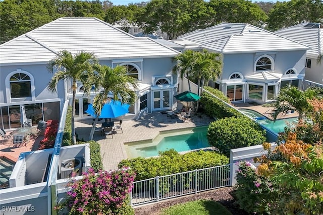 back of house featuring a fenced in pool, a fenced backyard, french doors, a patio area, and stucco siding