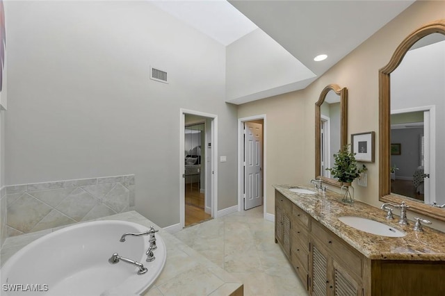 full bathroom featuring visible vents, a sink, a garden tub, and double vanity