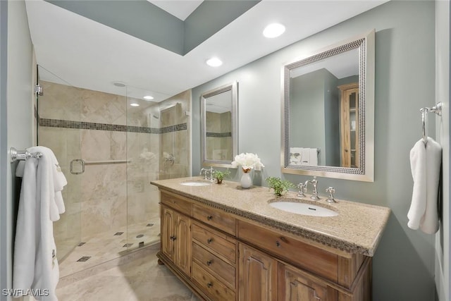 full bathroom featuring double vanity, a stall shower, a sink, and recessed lighting