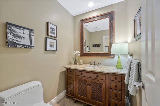 bathroom with toilet, baseboards, and vanity