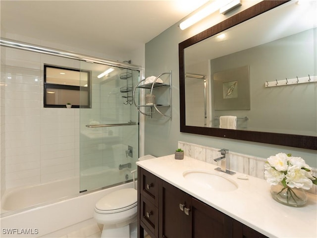 bathroom featuring toilet, vanity, and enclosed tub / shower combo