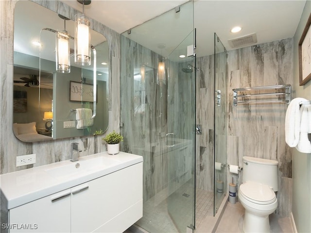 bathroom with tile walls, a marble finish shower, visible vents, toilet, and vanity