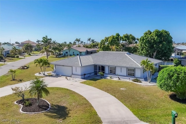 single story home featuring an attached garage, a tile roof, a front yard, and concrete driveway