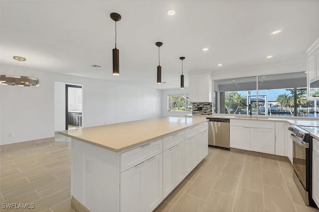 2501 Rio Grande Dr, Punta Gorda, FL 33950 - kitchen with stainless steel appliances, pendant lighting, white cabinets, and light countertops