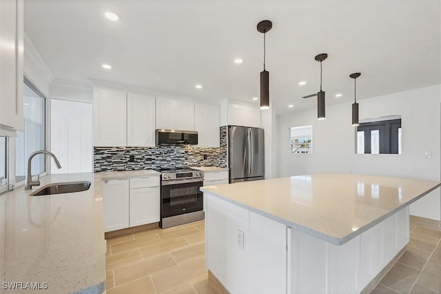 2501 Rio Grande Dr, Punta Gorda, FL 33950 - kitchen with a sink, a center island, appliances with stainless steel finishes, white cabinets, and decorative backsplash