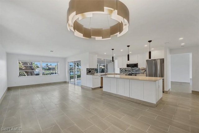 2501 Rio Grande Dr, Punta Gorda, FL 33950 - kitchen with tasteful backsplash, open floor plan, a center island, stainless steel appliances, and light countertops