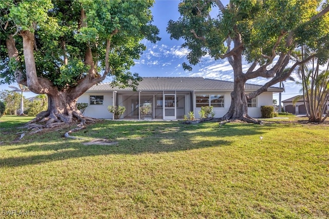 2501 Rio Grande Dr, Punta Gorda, FL 33950 - view of front of house with stucco siding, a tile roof, a front yard, and a sunroom