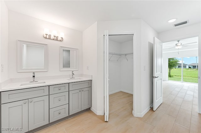 full bathroom featuring visible vents, a sink, a spacious closet, and baseboards