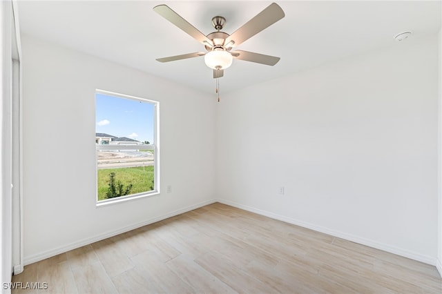 empty room with baseboards, ceiling fan, and light wood-style floors