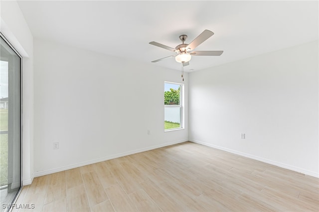 empty room featuring baseboards, a ceiling fan, and light wood-style floors