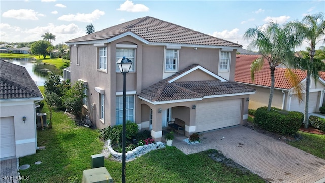 view of front facade featuring decorative driveway, a tile roof, stucco siding, a front yard, and central AC