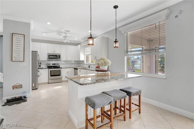 kitchen featuring ornamental molding, appliances with stainless steel finishes, light tile patterned floors, and tasteful backsplash