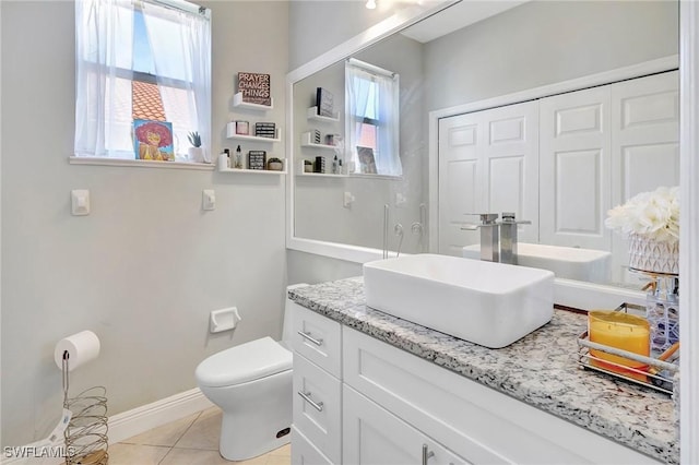 bathroom with baseboards, vanity, toilet, and tile patterned floors