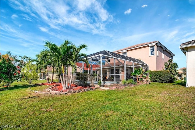 back of property with a lanai, a yard, and stucco siding