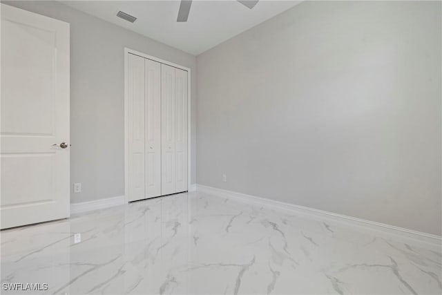 unfurnished bedroom with marble finish floor, a closet, visible vents, ceiling fan, and baseboards