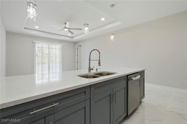 kitchen with dishwasher, marble finish floor, a tray ceiling, gray cabinets, and a sink