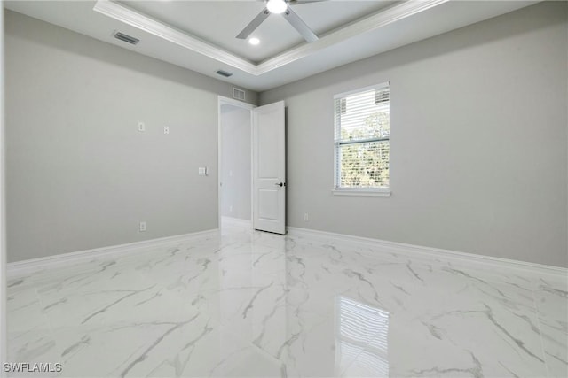 unfurnished room with marble finish floor, a tray ceiling, visible vents, and baseboards