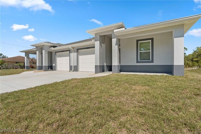 prairie-style home with an attached garage, driveway, a front lawn, and stucco siding