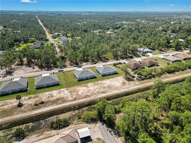 bird's eye view with a wooded view