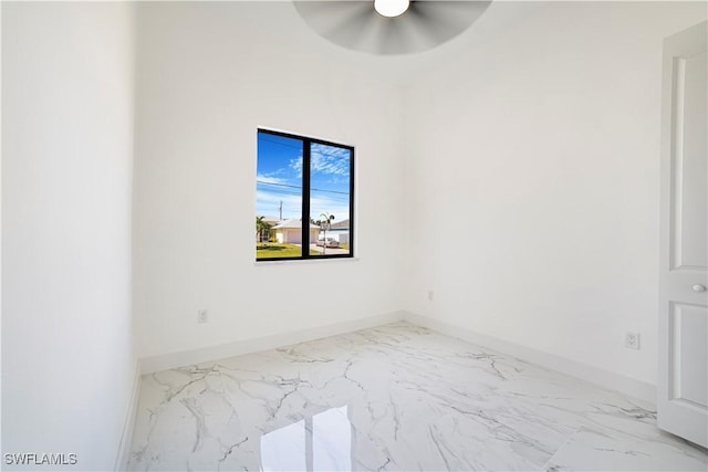 unfurnished room featuring marble finish floor, baseboards, and a ceiling fan