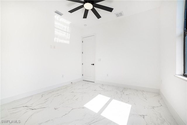 empty room featuring marble finish floor, visible vents, and baseboards