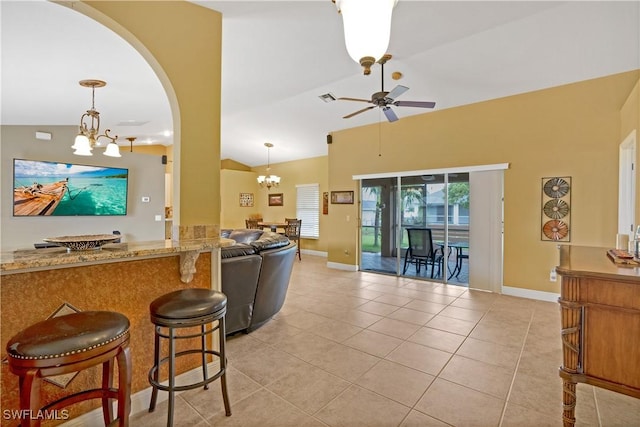 kitchen with light tile patterned floors, visible vents, open floor plan, vaulted ceiling, and ceiling fan with notable chandelier