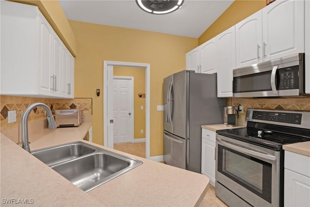 kitchen with appliances with stainless steel finishes, a sink, and white cabinets