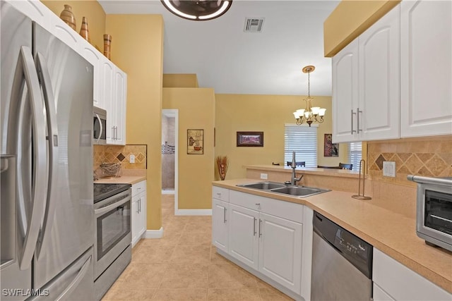 kitchen featuring stainless steel appliances, visible vents, light tile patterned flooring, a sink, and white cabinetry