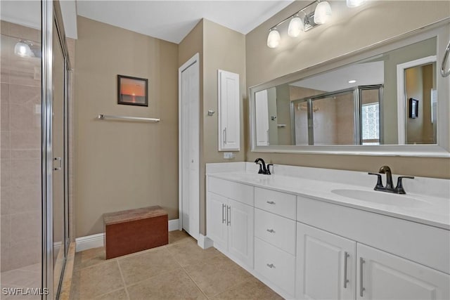 bathroom with tile patterned flooring, a sink, a shower stall, and double vanity