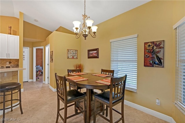 dining room featuring lofted ceiling, light tile patterned flooring, baseboards, and an inviting chandelier