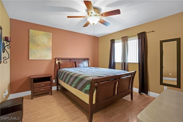 bedroom featuring light wood finished floors, baseboards, and a ceiling fan