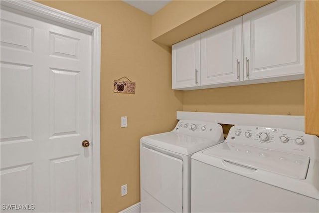 laundry area with independent washer and dryer and cabinet space