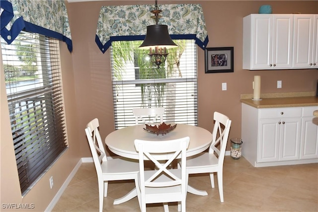 dining space featuring baseboards, an inviting chandelier, and light tile patterned floors