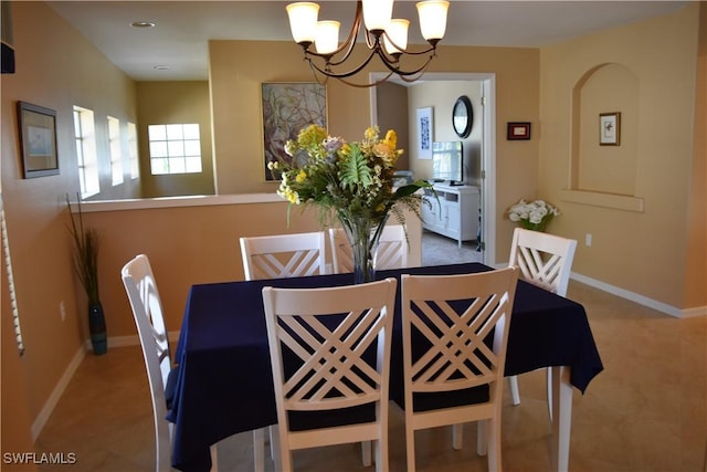 dining room with a chandelier and baseboards