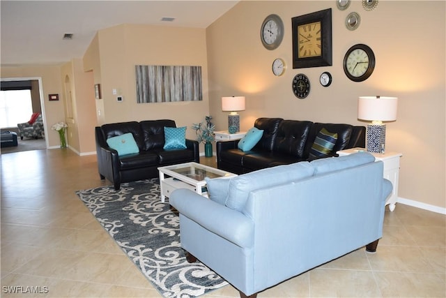 living area with tile patterned flooring, visible vents, and baseboards