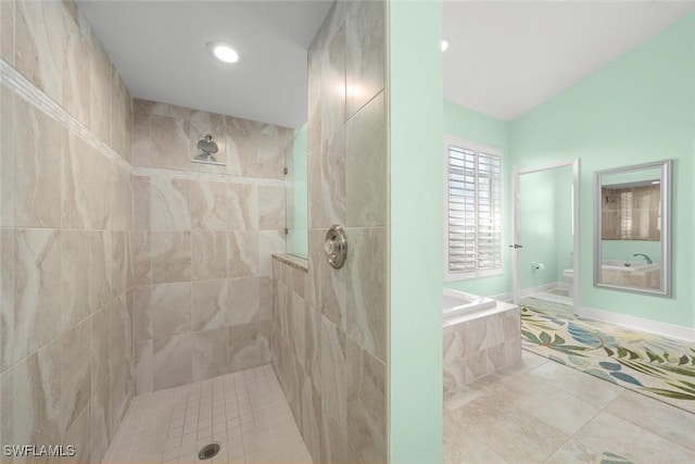 bathroom featuring a walk in shower, toilet, baseboards, a bath, and tile patterned floors