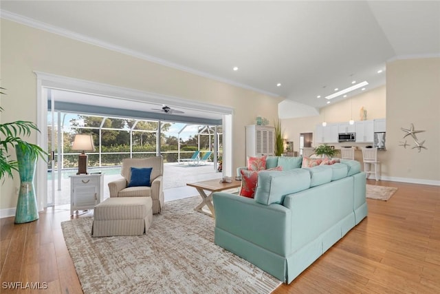 living area featuring ornamental molding, light wood-style flooring, and a sunroom