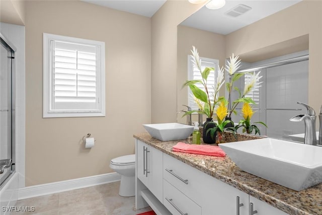 bathroom featuring double vanity, a sink, toilet, and baseboards