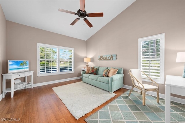 living room with ceiling fan, high vaulted ceiling, hardwood / wood-style floors, and baseboards