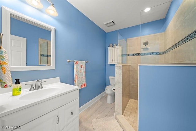 bathroom featuring vanity, baseboards, visible vents, walk in shower, and toilet