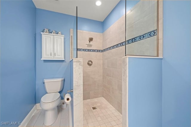 bathroom featuring tile patterned floors, baseboards, toilet, and walk in shower