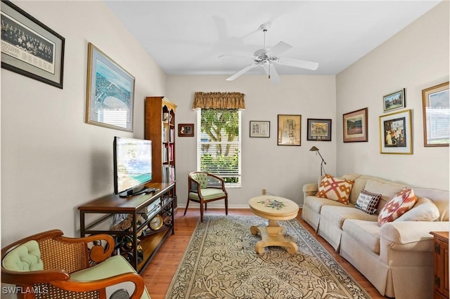 living room featuring light wood-style floors, baseboards, and a ceiling fan