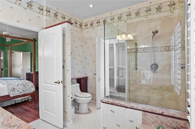 ensuite bathroom featuring a stall shower, ensuite bathroom, toilet, and tile patterned floors