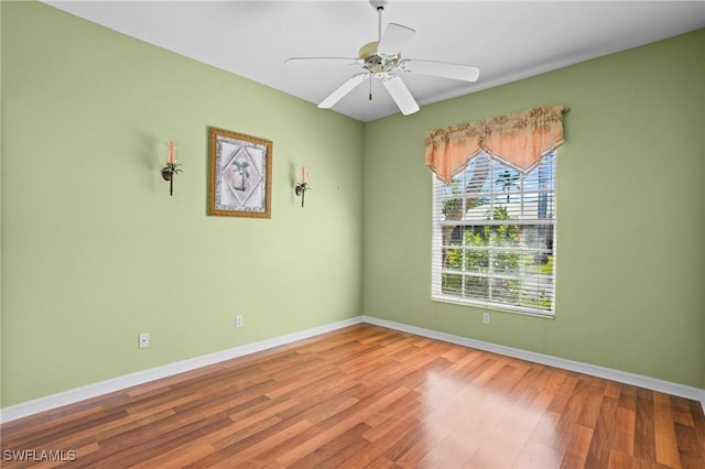 spare room with ceiling fan, baseboards, and wood finished floors