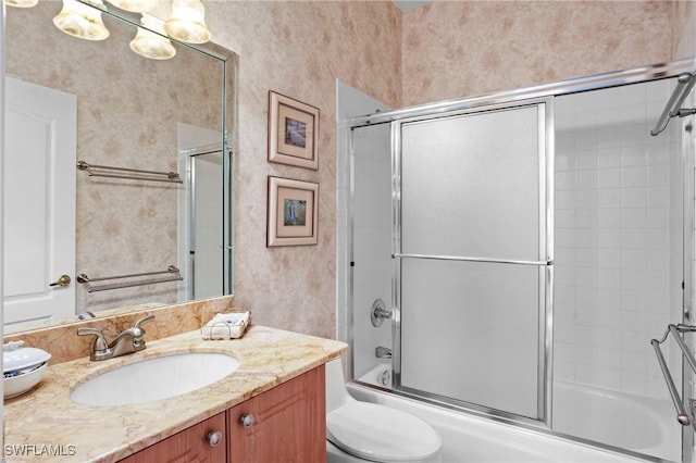 full bathroom featuring combined bath / shower with glass door, vanity, and toilet